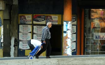 epa10279177 A man walks in front of posters reading in Serbian language 'No surrender, KM (Kosovska Mitrovica) stays' in the northern Serb-dominated part of ethnically divided town of Mitrovica, Kosovo, 01 November 2022. The Government of Kosovo will begin implementing a plan to eliminate the usage of Serbian car license plates. All owners of vehicles with Serbian number plates are warned and requested to visit any of the Vehicle Registration Centers and register their vehicles with RKS license plates. In the Serbian community of Kosovo, the RKS license plates are seen as unacceptable as they suggest the recognition of independence of the Republic of Kosovo.  EPA/DJORDJE SAVIC