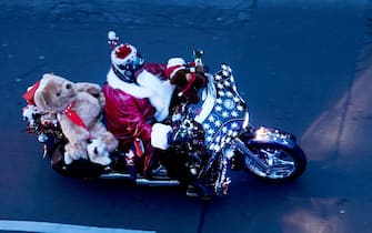 12 December 2020, Berlin: With a huge teddy bear and dressed as Santa Claus, a motorcyclist rides along Torstrasse. Over a hundred Santa Clauses are taking part in the 23rd Berlin Christmas Bike Tour 2020. Photo: Annette Riedl/dpa