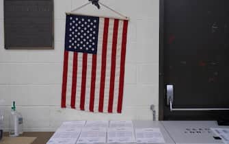 epa10294949 An American flag hangs above ballots at the Boyle Heights Senior Center in Los Angeles, California, USA, 08 November 2022. The US midterm elections are held every four years at the midpoint of each presidential term and this year include elections for all 435 seats in the House of Representatives, 35 of the 100 seats in the Senate and 36 of the 50 state governors as well as numerous other local seats and ballot issues.  EPA/ALLISON DINNER
