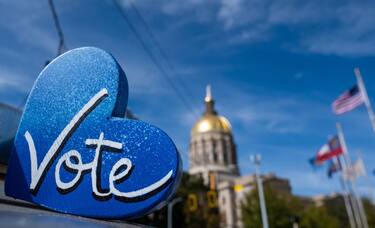 The Georgia State Capitol building is seen behind a "Vote" sign, a day after the US midterm election, in Atlanta, Georgia, on November 9, 2022. - The US Senate contest in Georgia that could determine which party controls the upper chamber of Congress is headed for a December runoff, media projections showed on November 9, 2022. (Photo by SETH HERALD / AFP) (Photo by SETH HERALD/AFP via Getty Images)