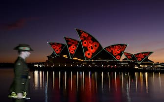 epa10298704 Poppies are projected onto the Sydney Opera House sails during a Remembrance Day 2022 Dawn Service at Campbells Cove in Sydney, Australia, 11 November 2022. Remembrance Day is observed in Australia on 11 November to commemorate those who died serving their country in all wars and armed conflicts.  EPA/BIANCA DE MARCHI AUSTRALIA AND NEW ZEALAND OUT