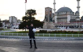 A Turkish policeman gestures as he tries to secure the area after a strong explosion of unknown origin shook the busy shopping street of  Istiklal in Istanbul, on November 13, 2022. - Istanbul governor Ali Yerlikaya tweeted that four people died and 38 were wounded according to preliminary information. (Photo by Yasin AKGUL / AFP) (Photo by YASIN AKGUL/AFP via Getty Images)