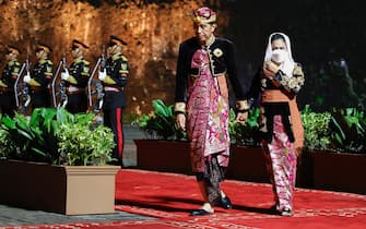 epa10306753 Indonesian President Joko Widodo (C) and his wife Iriana Joko Widodo (R) review the honor guard at a Welcoming Dinner of the G20 Leaders' Summit at the Garuda Wisnu Kencana Cultural Park in Bali, Indonesia, 15 November 2022. The 17th Group of Twenty (G20) Heads of State and Government Summit runs from 15 to 16 November 2022.  EPA/WILLY KURNIAWAN / POOL