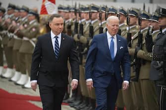 epa09850741 Polish President Andrzej Duda (L) and US President Joe Biden (R) review an honor guard during an official welcome ceremony at the Presidential Palace in Warsaw, Poland, 26 March 2022. US President Biden arrived in Poland for a two-days visit during which he is scheduled to hold talks with his Polish counterpart and make an address at the Royal Castle in Warsaw. Biden is coming to Poland straight from Brussels, where he attended an extraordinary Nato summit, a European Council meeting and a G7 summit on 24 March.  EPA/Marcin Obara POLAND OUT