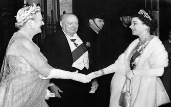 Queen Elizabeth II is greeted by Lady Churchill and Sir Winston Churchill, as she arrives for a dinner party at No. 10 Downing Street.