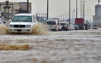 Cars drive through a flooded street following heavy rains in the Saudi coastal city of Jeddah on November 24, 2022, which delayed flights, forced school suspensions and closed the road to Mecca, Islam's holiest city. - Jeddah, a city of roughly four million people positioned on the Red Sea, is often referred to as the "gateway to Mecca", where millions perform the hajj and umrah pilgrimages each year. Winter rainstorms and flooding occur almost every year in Jeddah, where residents have long decried poor infrastructure. (Photo by Amer HILABI / AFP) (Photo by AMER HILABI/AFP via Getty Images)