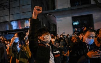 People sing slogans while gathering on a street in Shanghai on November 27, 2022, where protests against China's zero-Covid policy took place the night before following a deadly fire in Urumqi, the capital of the Xinjiang region. (Photo by Hector RETAMAL / AFP)