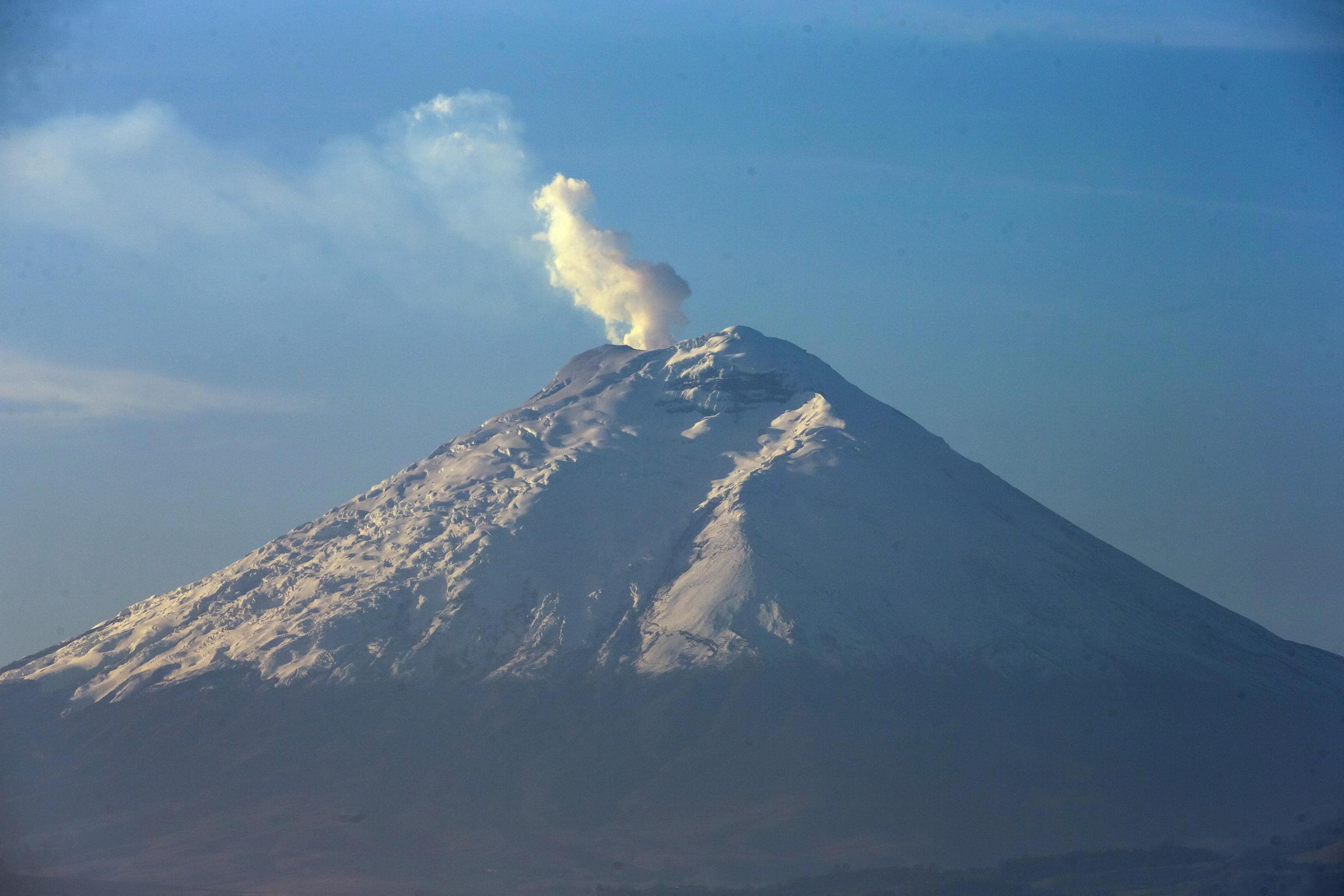 epa10324867 The Cotopaxi volcano with a steam fumarole as seen from Quito, Ecuador, 24 November 2022. In a report the Geophysical Institute (IG), recalled that on October 21 a low-frequency tremor signal associated with an emission of gasses and ash was recorded, which produced a moderate fall of this material on the northern flank of the volcano. Since then, the emission of gasses has been almost continuous and clearly visible, with columns that have reached up to two kilometers above the level of the crater.  EPA/JOSE JACOME