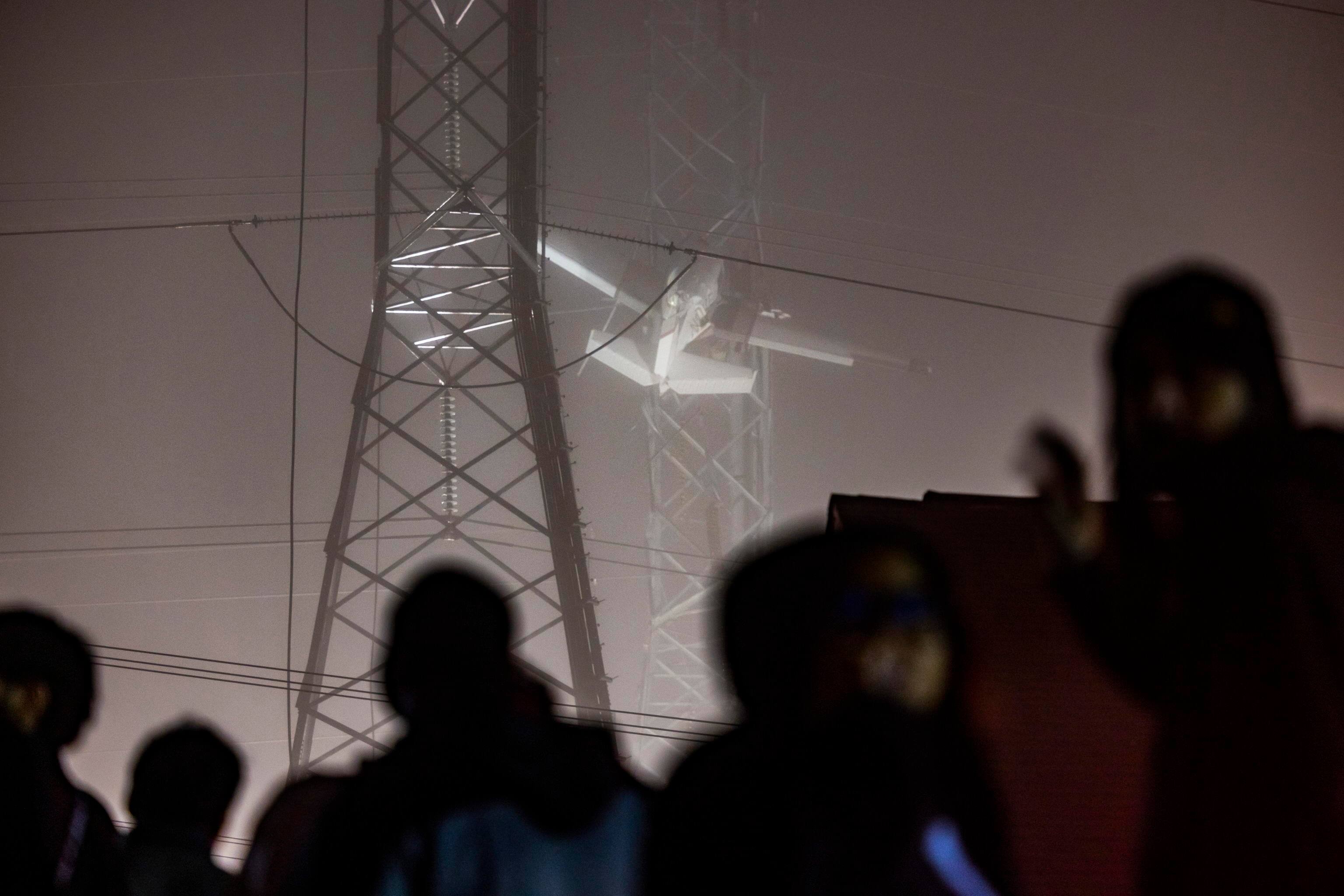 epa10333584 People watch a small plane that crashed into a power line, knocking out electricity for tens of thousands of residents, in Gaithersburg, Maryland, USA, 28 November 2022.  EPA/JIM LO SCALZO