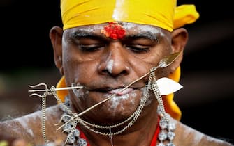 KUALA LUMPUR, MALAYSIA - 2022/01/18: A Hindu devotee seen with his mouth pierced with metal rods before the procession during the Thaipusam festival at the Batu Caves Temple.
Thaipusam is an annual Hindu festival celebrated mostly by the Tamil community in honor of the Hindu god Lord Murugan.
Devotees will blessings and make vows when their prayers are answered. (Photo by Wong Fok Loy/SOPA Images/LightRocket via Getty Images)