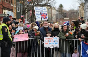 A crowd waits to get a glimpse of the royals during the visit of Britain's Prince William, Prince of Wales, and Catherine, Princess of Wales, to Roca Inc, an organization working to reduce urban violence through community engagement efforts, in Chelsea, Massachusetts, on December 1, 2022. (Photo by Nancy Lane / POOL / AFP) (Photo by NANCY LANE/POOL/AFP via Getty Images)