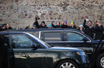 Onlookers take cellphone photos of the motorcade of Britain's Prince William and Catherine, Princess of Wales after a visite at the Harbour Defenses of Boston in Boston, Massachusetts, on December 1, 2022. (Photo by David L. RYAN / POOL / AFP) (Photo by DAVID L. RYAN/POOL/AFP via Getty Images)