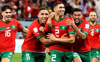 epa10352472 Players of Morocco celebrate with Achraf Hakimi (C) after he scored the last penalty kick which sent Morocco to the quarter final during the FIFA World Cup 2022 round of 16 soccer match between Morocco and Spain at Education City Stadium in Doha, Qatar, 06 December 2022.  EPA/Mohamed Messara