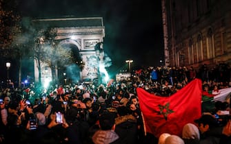 epa10352742 Fans of Morocco celebrate after the team won the FIFA World Cup 2022 round of 16 soccer match between Morocco and Spain on the Champs-Elysees in Paris, France, 06 December 2022. EPA/YOAN VALAT