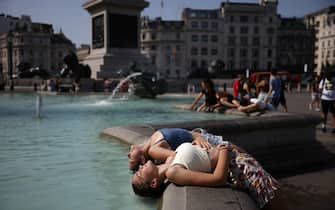 LONDON, ENGLAND - JULY 19: Two women dip their heads into the fountain to cool off in Trafalgar Square on July 19, 2022 in London, United Kingdom. Temperatures were expected to hit 40C in parts of the UK this week, prompting the Met Office to issue its first red extreme heat warning in England, from London and the south-east up to York and Manchester. (Photo by Dan Kitwood/Getty Images)