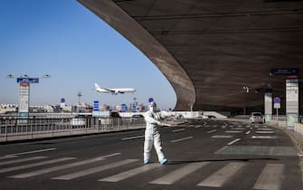 BEIJING, CHINA - FEBRUARY 21: An airport staff member in a hazmat suit monitors traffic outside the entrance of the Beijing Capital International Airport on February 21, 2022 in Beijing, China. Officials, athletes, and media have started to leave Beijing after the closing ceremony of the Beijing 2022 Winter Olympics. (Photo by Annice Lyn/Getty Images)