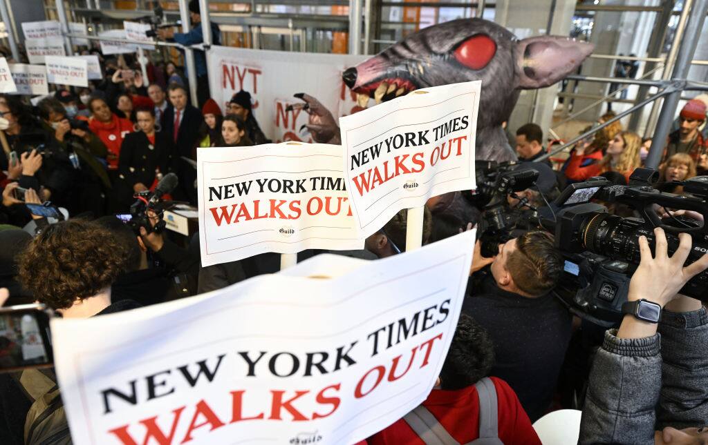 NEW YORK, UNITED STATES - DECEMBER 08: Employees of the New York Times (NYT) gather as they hold banners to protest the newspaper management in front of the New York Times building after the negotiations between the union and the management failed in New York, United States on December 08, 2022. New York Times employees went on a 24-hour walkout. (Photo by Fatih Aktas/Anadolu Agency via Getty Images)