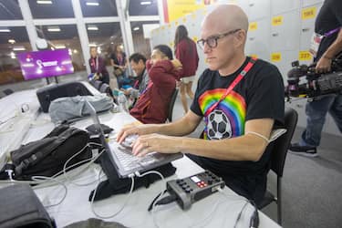 AL RAYYAN, QATAR - NOVEMBER 21: Journalist Grant Wahl (right) works in the FIFA Media Center before a FIFA World Cup Qatar 2022 Group B match between Wales and USMNT at Ahmad Bin Ali Stadium on November 21, 2022 in Al Rayyan, Qatar. He had been detained earlier by stadium security for wearing a rainbow-colored t-shirt before later being allowed to enter the stadium. (Photo by Doug Zimmerman/ISI Photos/Getty Images)