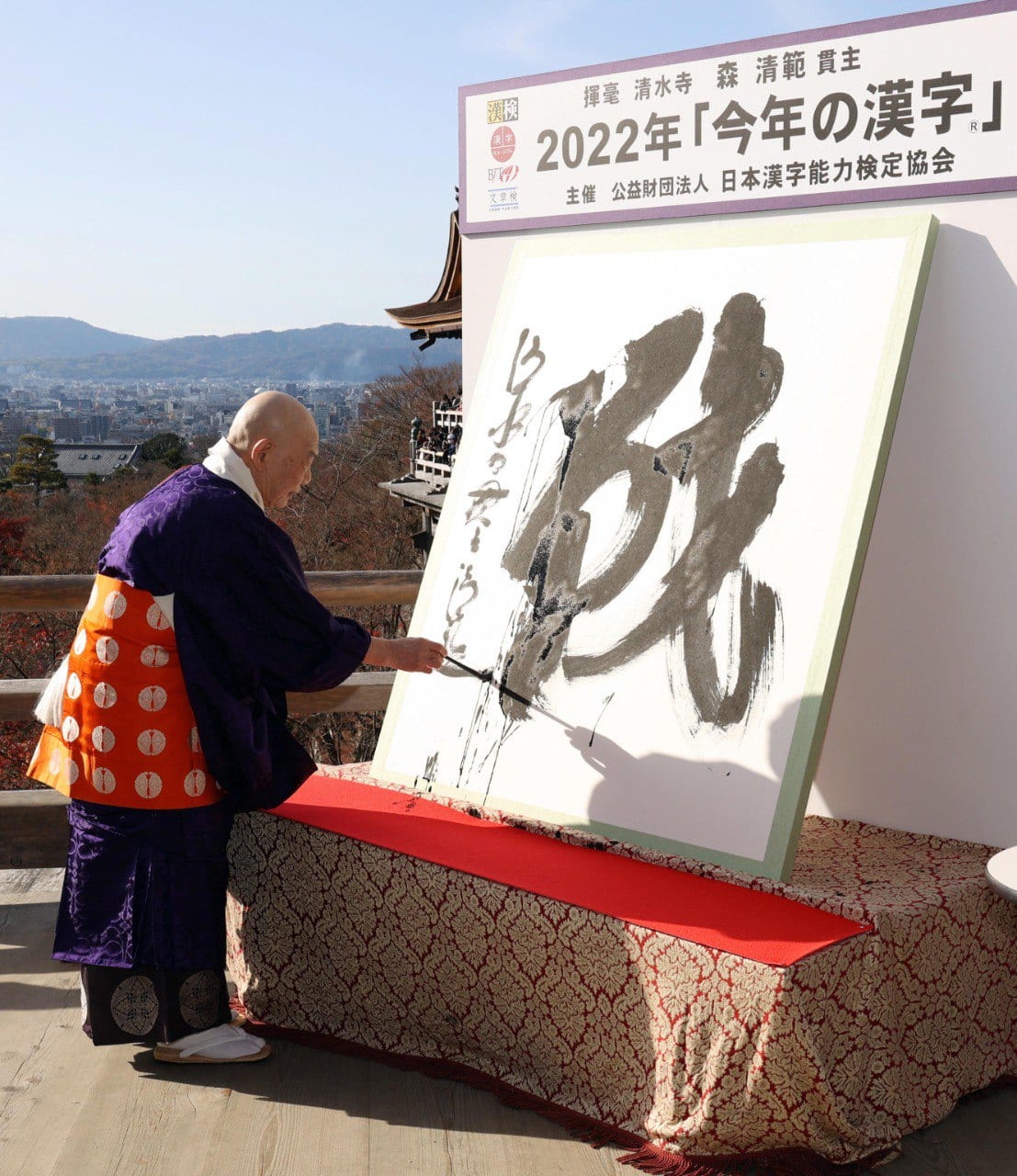 Il sacerdote buddista Seihan Mori scrive il carattere nei pressi del tempio di Kyoto
