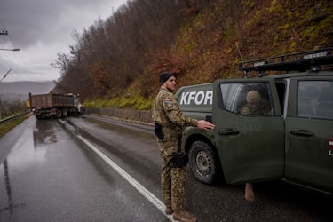 NATO soldiers serving in the peacekeeping mission in Kosovo (KFOR) inspect a road barricade set up by ethnic Serbs near the town of Zubin Potok on December 11, 2022. - Hundreds of ethnic Serbs erected barricades on a road in northern Kosovo on Saturday, blocking the traffic over the two main border crossings towards Serbia, police said. Trucks, ambulance cars and agricultural machines were used as roadblocks, heightening recent tensions which included explosions, shootings and an armed attack on a police patrol which saw one ethnic Albanian police officer wounded. (Photo by Armend NIMANI / AFP) (Photo by ARMEND NIMANI/AFP via Getty Images)
