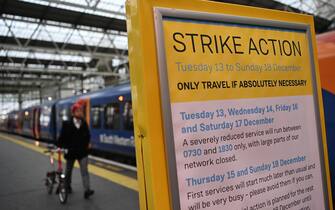 epa10363032 A commuter at Waterloo Station in London, Britain, 13 December 2022. Members of the RMT rail workers' union are beginning fresh wave of strike action causing major disruption to the UK's rail network. Over forty thousand rail workers are walking out on strike in the first of a series of rail strikes during the festive period over an on-going dispute over pay and working conditions.  EPA/ANDY RAIN