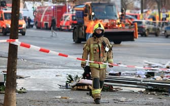 BERLIN, GERMANY - DECEMBER 16: Emergency workers respond at the scene of a broken giant aquarium, on December 16, 2022 in Berlin, Germany. The aquarium, located in the Radisson Hotel in the DomaquarÃ©e complex, spilled approximately 1,500 exotic fish and pushed debris from the hotelâ  s lobby out onto a heavy pedestrian and traffic thoroughfare when it burst in the early morning. The owners claim the aquarium, which houses the hotelâ  s central guest elevator and flooded the hotel with one million liters (264,172 gallons) when it broke, is the world's largest freestanding cylindrical one at 14 meters (46 feet) in height. (Photo by Adam Berry/Getty Images)