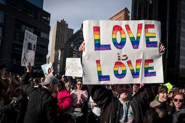 NEW YORK, NY - JANUARY 20: A demonstrator holds up a  banner saying "Love Is Love" in front of Trump International Hotel and Tower during the second annual Women's March in the borough of Manhattan in New York City, U.S. on Saturday, January 20, 2018.  One year after the inauguration of President Donald Trump, thousands of people will again gather to protest for equal rights at the 2018 Women's March.  (Photo by Ira L. Black/Corbis via Getty Images)
