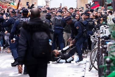 TOPSHOT - Protestors clash with French riot police officers following a statement by French Interior Minister at the site where several shots were fired along rue d'Enghien in the 10th arrondissement, in Paris on December 23, 2022. - Three people were killed and three injured in a shooting in central Paris on December 23, 2022, police and prosecutors said, adding that the shooter, in his 60s, had been arrested. The motives of the gunman remain unclear, with two of the four injured left in a serious condition, the French officials said. (Photo by Thomas SAMSON / AFP) (Photo by THOMAS SAMSON/AFP via Getty Images)