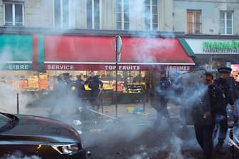 French riot police officers run to disperse protestors during a clash following a statement by French Interior Minister at the site where several shots were fired along rue d'Enghien in the 10th arrondissement, in Paris on December 23, 2022. - Three people were killed and three injured in a shooting along rue d'Enghien in central Paris on December 23, 2022, police and prosecutors said, adding that the shooter, in his 60s, had been arrested. (Photo by Thomas SAMSON / AFP) (Photo by THOMAS SAMSON/AFP via Getty Images)