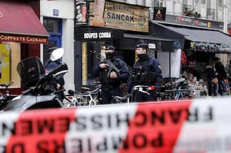 epa10377080 Armed police officers secure the perimeter on 'Rue d'Enghien' following a shooting incident near a Kurdish cultural centre in Paris, France, 23 December 2022. The Paris Police Prefecture annonced on its social media that a suspect was detained in connection to the incident.  EPA/TERESA SUAREZ