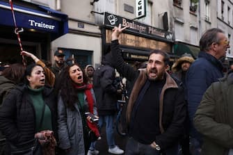 People shout slogans following a shooting along rue d'Enghien in the 10th arrondissement, in Paris on December 23, 2022. - Three people were killed and four injured in a shooting along rue d'Enghien in central Paris on December 23, 2022, police and prosecutors said, adding that the shooter, in his 60s, had been arrested. (Photo by Thomas SAMSON / AFP) (Photo by THOMAS SAMSON/AFP via Getty Images)