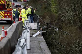 Emergency services members stand on a bridge after a bus plunged in the Lerez river while crossing, killing four people, in Cerdedo-Cotobade, northwestern Spain, on December 25, 2022. - The accident occurred on December 24 night near Vigo and the border with Portugal. The regional La Voz de Galicia newspaper said the bus was carrying people visiting their loved ones jailed in Monterroso in central Galicia. Rescue operations had to be suspended overnight due to bad weather but resumed in the morning. (Photo by Brais Lorenzo / AFP) (Photo by BRAIS LORENZO/AFP via Getty Images)
