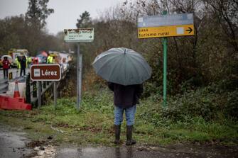 A resident looks on as emergency services are at work on a bridge above the Lerez river after a bus plunged while crossing, killing four people, in Cerdedo-Cotobade, northwestern Spain, on December 25, 2022. - The accident occurred on December 24 night near Vigo and the border with Portugal. The regional La Voz de Galicia newspaper said the bus was carrying people visiting their loved ones jailed in Monterroso in central Galicia. Rescue operations had to be suspended overnight due to bad weather but resumed in the morning. (Photo by Brais Lorenzo / AFP) (Photo by BRAIS LORENZO/AFP via Getty Images)