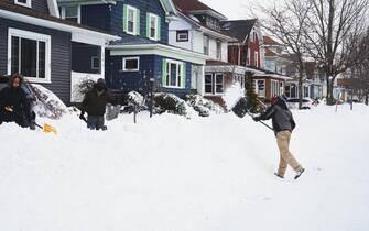 epa10378187 People clear their driveways of snow as the effects of a massive winter storm which has affected large portions of the United States, continues in Buffalo, New York, USA, 25 December 2022. Much of the United States is currently experiencing some sort of winter weather as a result of the large storm which was generated by a bomb cyclone, the meteorological phenomenon when the atmospheric pressure quickly drops in a strong storm  EPA/JOSH THERMIDOR