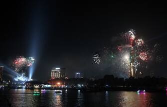 epa10384527 Fireworks explode around the Cairo tower during the New Year celebrations, in Cairo, Egypt on 01 January 2023.  EPA/KHALED ELFIQI