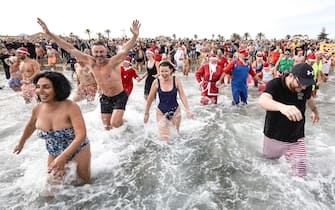 epa10385244 Several British residents attend the traditional New Year's swim at Arenal beach in Javea, Alicante, eastern Spain, Spain, 01 January 2023. The charity event is to rise funds for Red Cross.  EPA/Natxo Frances