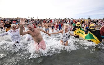 epa10385245 Several British residents attend the traditional New Year's swim at Arenal beach in Javea, Alicante, eastern Spain, Spain, 01 January 2023. The charity event is to rise funds for Red Cross.  EPA/Natxo Frances