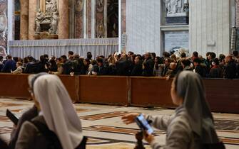 People observe a moment of silence as the body of the late Pope Emeritus Benedict XVI (Joseph Ratzinger) lies in the state in the Saint Peter Basilica for public viewing, Vatican City, 03 January 2023. ANSA/FABIO FRUSTACI