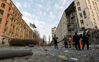 epa10383860 Policemen and rescuers stand in front of damaged hotel building that was hit in a missile strrike in downtown Kyiv (Kiev), Ukraine, 31 December 2022. Russian missiles targeted major cities across Ukraine on 31 December prior to the New Year celebration. Kyiv Mayor Vitaliy Klitschko reported explosions and destruction in three districts of the capital. At least one person was killed, Klitschko said. Russian troops entered Ukraine on 24 February 2022 starting a conflict that has provoked destruction and a humanitarian crisis.  EPA/OLEG PETRASYUK