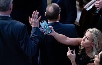 È diventata virale, con oltre 10 milioni di visualizzazioni su Twitter, la foto nella quale la trumpiana Marjorie Taylor-Greeene mostra ai suoi colleghi di partito il suo Iphone mentre la chiamava DT, Donald Trump. La foto è stata scattata da Al Drago, giornalista di Bloomberg