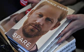 epa10397376 A person holds copies of Prince Harry's memoir SPARE during a midnight sale at a book shop in London, Britain, 10 January 2023. Prince Harry's controversial new memoir SPARE goes on sale across Britain on 10 January.  EPA/ANDY RAIN