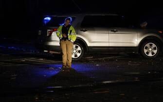 epa10402474 A police officer listens to her radio as she mans a roadblock among downed power lines following an outbreak across multiple states in Griffin, Georgia, USA, 12 January 2023.  EPA/ERIK S. LESSER