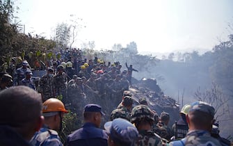 Rescuers gather at the site of a plane crash in Pokhara on January 15, 2023. - An aircraft with 72 people on board crashed in Nepal on January 15, Yeti Airlines and a local official said. (Photo by Yunish Gurung / AFP) (Photo by YUNISH GURUNG/AFP via Getty Images)