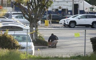 epa10423321 A Crime Scene technician collects evidence in a parking lot after a mass shooting at a dance studio in Monterey Park, California, USA, 22 January 2023. The shooting killed ten and wounded ten more during a Lunar New Year celebration according to the Los Angeles County Sheriff's Department.  EPA/DAVID SWANSON