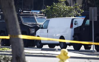 epa10423874 A white van which police reported was connected with a mass shooting at a dance studio in Monterey Park, California, sits trapped between two heavily armored police vehicles in Torrance, California, USA, 22 January 2023. The shooting killed ten and wounded ten more during a Lunar New Year celebration according to the Los Angeles County Sheriff's Department.  EPA/CAROLINE BREHMAN