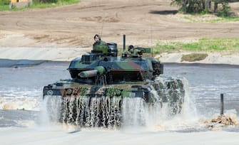 20 May 2019, Lower Saxony, Munster: During a demonstration of the Very High Readiness Joint Task Force (VJTF) a Leopard 2 main battle tank with a short deep wading shaft comes out of a water basin. In 2019, Germany will be responsible for the Nato rapid reaction force. Photo: Christophe Gateau/dpa