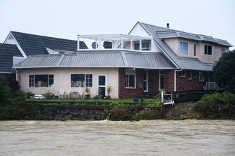 A home is seen next to the Maitai river after it burst its banks in Nelson on August 18, 2022, as the city experienced flash floods caused by a storm. - Hundreds of families on New Zealand's South Island were forced to leave their homes on August 18 after flooding caused a state of emergency to be declared in three regions. (Photo by Chris Symes / AFP) (Photo by CHRIS SYMES/AFP via Getty Images)