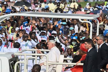 Pope Francis (C) waves as he arrives on the popemobile for the mass at the N'Dolo Airport in Kinshasa, Democratic Republic of Congo (DRC), on February 1, 2023. (Photo by Tiziana FABI / AFP) (Photo by TIZIANA FABI/AFP via Getty Images)