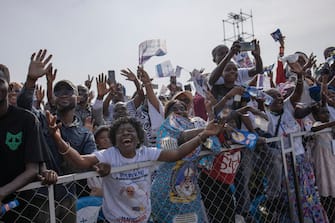 A woman gestures as attendees cheer while Pope Francis (not seen) arrives for the mass at the N'Dolo Airport in Kinshasa, Democratic Republic of Congo (DRC), on February 1, 2023. (Photo by Guerchom Ndebo / AFP) (Photo by GUERCHOM NDEBO/AFP via Getty Images)