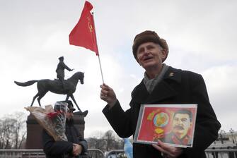 epa10444183 A Russian Communist party supporter holds a portrait of Soviet leader Joseph Stalin in front of the monument to Soviet Red Army marshal Georgy Zhukov, before a wreath laying ceremony at the memorial stone for World War II Hero City Stalingrad to commemorate the 80th anniversary of the Battle of Stalingrad in Moscow, Russia, 02 February 2023. Russia celebrates the 80th anniversary of the end of the Battle of Stalingrad, in the southern Russian city of Volgograd, once known as Stalingrad, that was a turning point in World War II and led to the defeat of Nazi Germany.  EPA/MAXIM SHIPENKOV